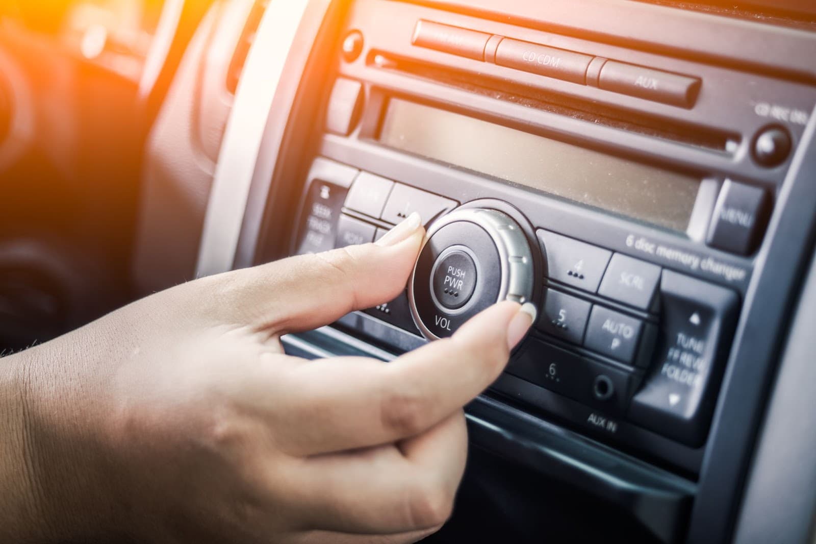 Close up of hand touching the radio dial.