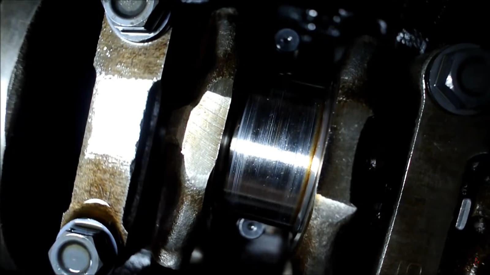Close-up view of an engine's internal components, showcasing a connecting rod and shiny metal surfaces