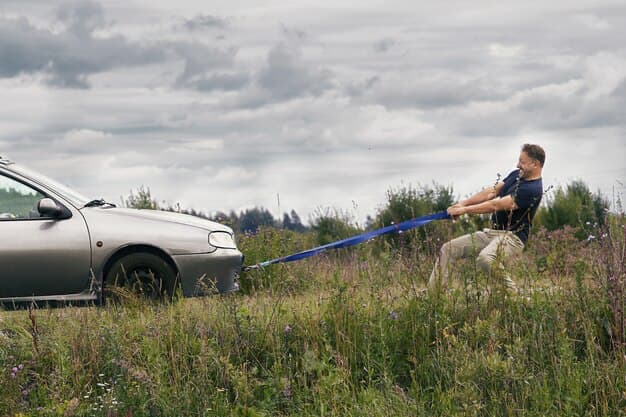 A man independently pulls a car with a towing strap